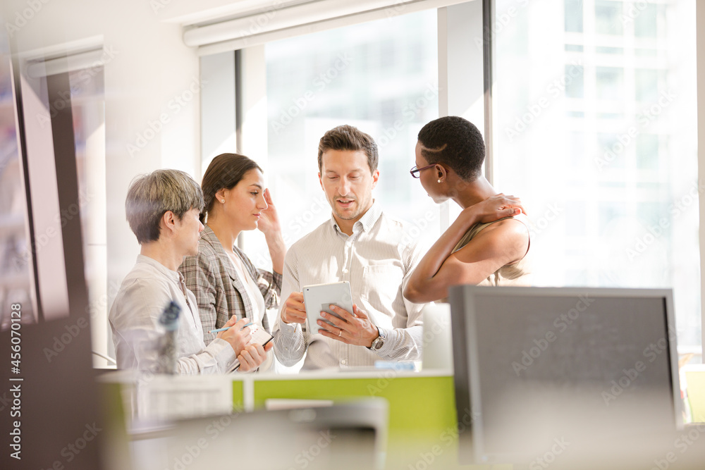 Business people talking in open plan office Business people talking in open plan office