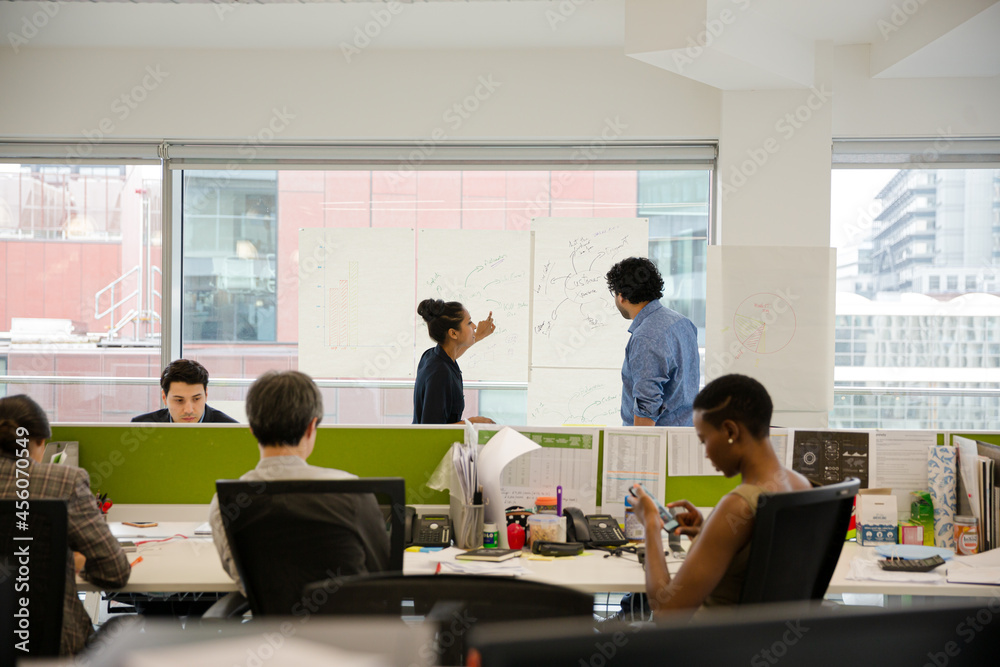 Fototapeta premium Business people discussing diagram sketches hanging on office window