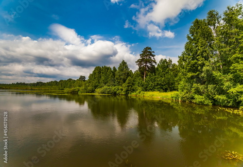 River banks against blue sky with white clouds in summer