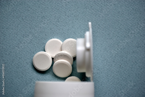 White flat medicine tablets on a blue background