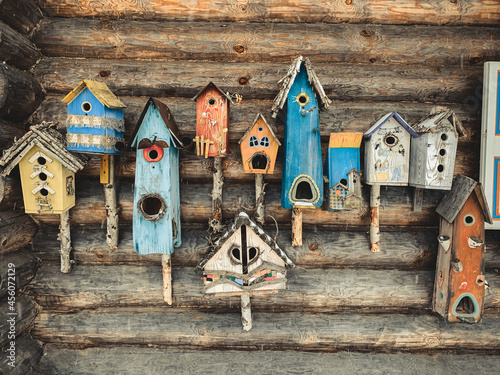 Canvas-taulu a large number of colorful birdhouses on the wall of the log cabin