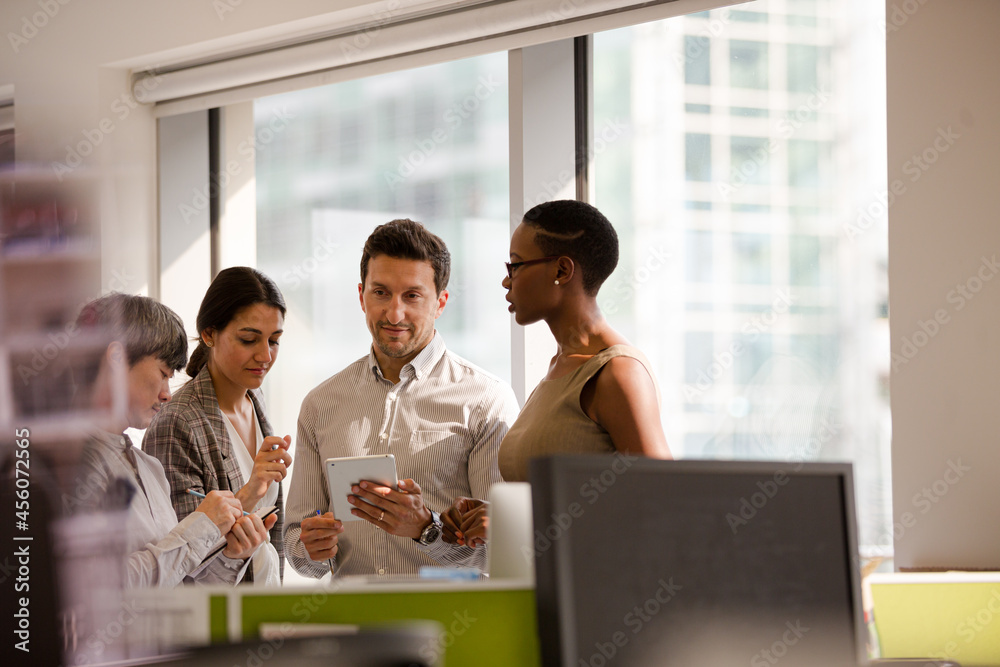 Business people talking in open plan office Business people talking in open plan office