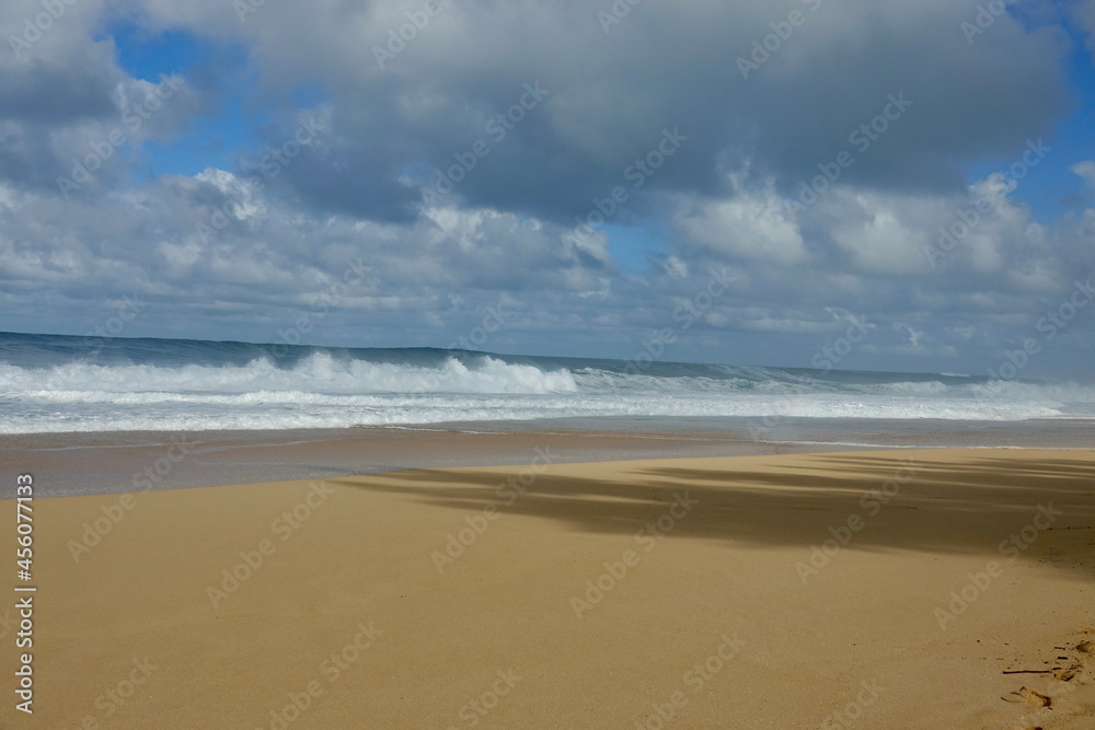 empty tropical beach with waves rolling onto the sand