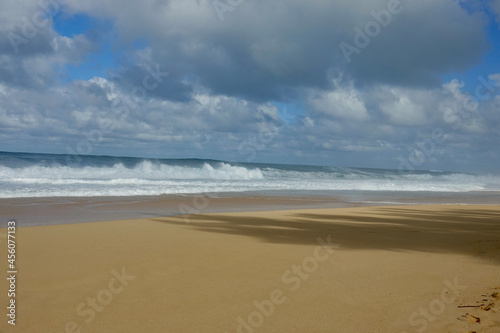 empty tropical beach with waves rolling onto the sand