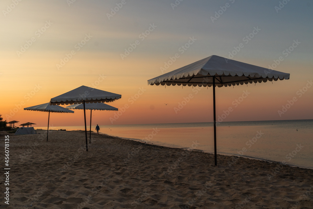 Beach umbrellas in the colors of the rising sun in the Black Sea resort.