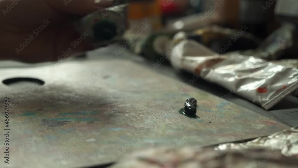 An artist opens a tube of paint Preparing paint for a painting An artist opens a tube of paint Preparing paint for a painting