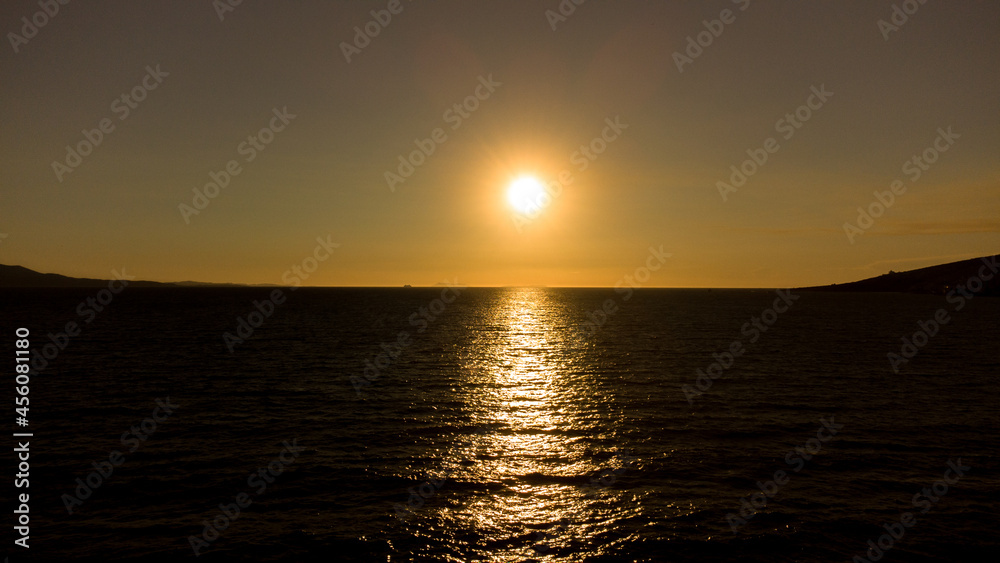 Naklejka premium Bright sunset with large yellow sun under the sea surface