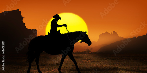 Cowboy on horseback at sunset