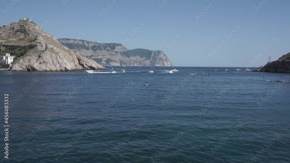 View of Balaklava bay with yachts from the Genoese fortress Chembalo. View from the marble beach to the exit from the bay to the open sea. In the background, Cape Aya Nature Reserve. Crimea. View of Balaklava bay with yachts from the Genoese fortress Chembalo. View from the marble beach to the exit from the bay to the open sea. In the background, Cape Aya Nature Reserve. Crimea.