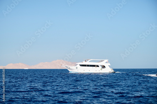 Yacht in the open sea on the background of a mountain © Ihar
