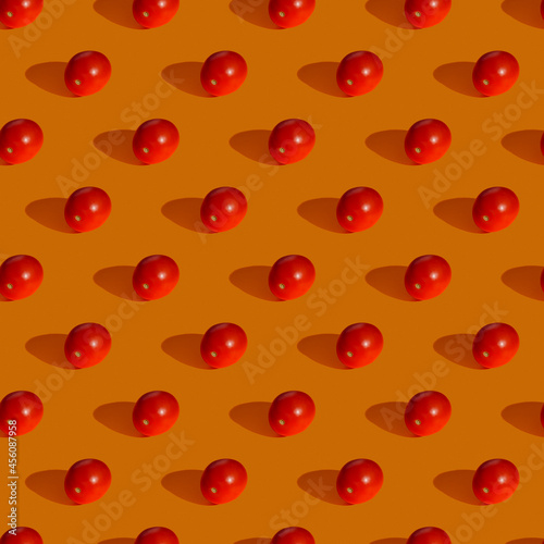 Seamless pattern made from tomato on orange background, Flat lay photo