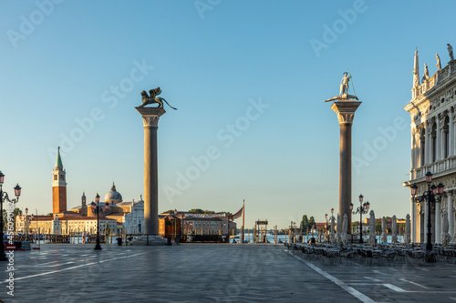 early morning view with rising sun to pillar with lion and dragon fighter at St. Mark's square in Venice photo