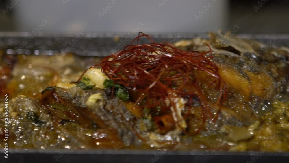 Slow motion of frying fish cooking on cast iron pan in the kitchen restaurant. Appetizer taiwanese seafood style on griddle. Delicious healthy food for dinner at Taiwan-Dan Slow motion of frying fish cooking on cast iron pan in the kitchen restaurant. Appetizer taiwanese seafood style on griddle. Delicious healthy food for dinner at Taiwan-Dan