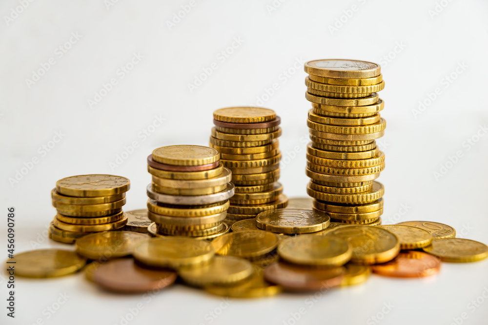 Stacks of euro coins placed on white surface. Money and value of money.
Stacks of euro coins placed on white surface. Money and value of money.