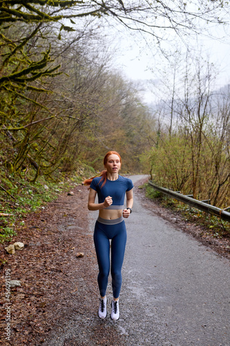 Running woman. Fitness woman Runner jogging outside in forest. caucasian woman training outdoor, fit slim female athlete model in motion, workout alone. urban sport concept. copy space