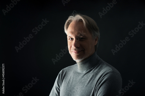 Attractive mature man with beard on plain background wearing casual 