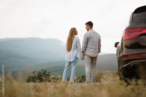 Young couple on trip relaxing and enjoying the view of mountains