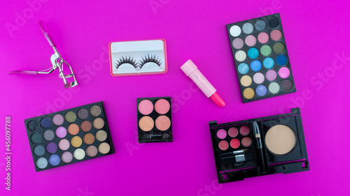 Multicolored beautiful eyeshadow palette and Various cosmetic accessories for makeup on pink background Beauty products Makeup cosmetic Summer eye shadow