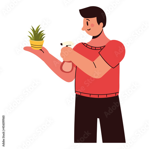 man sprays a houseplant