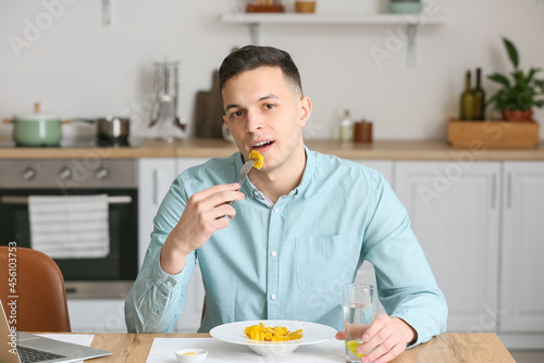 Young man eating tasty ravi...