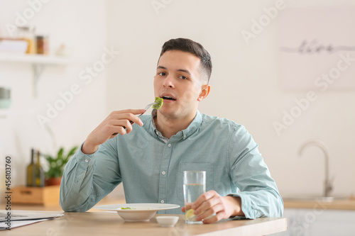 Young man eating tasty ravi...