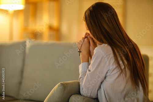Praying young woman at home...