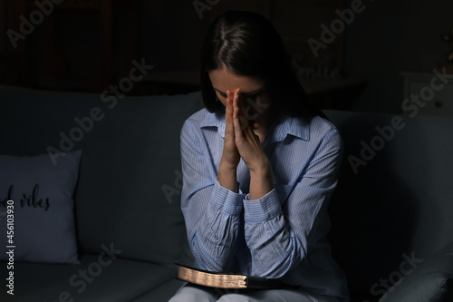 Praying young woman at home...