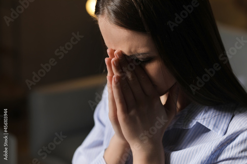 Praying young woman at home...