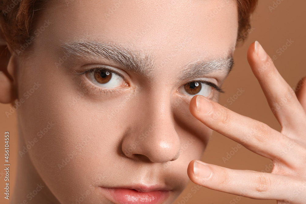 Teenage boy with dyed eyebrows on color background, closeup Teenage boy with dyed eyebrows on color background, closeup