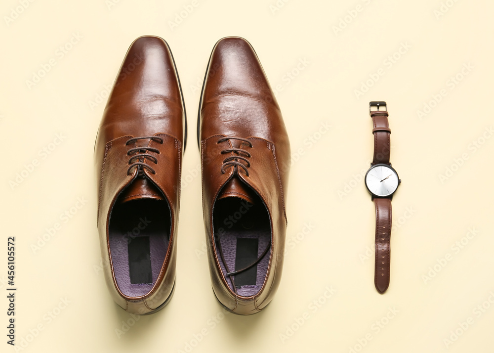 Classic leather male shoes and hand watch on color background Classic leather male shoes and hand watch on color background