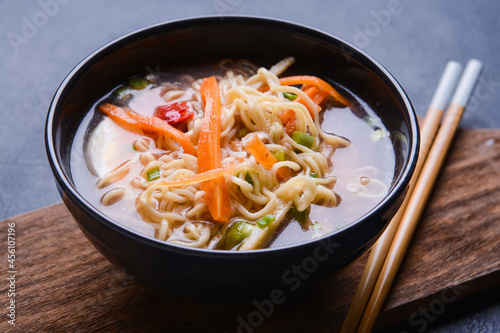 Tasty Chinese soup in bowl on dark background, closeup