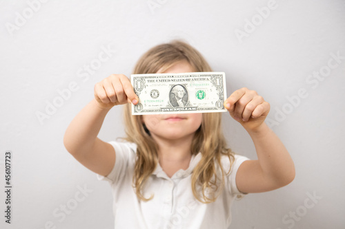 A child holding a banknote in his hands 