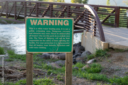Warning sign informing visitors to the river of a no swimming area, this is a white water rafting boarding area