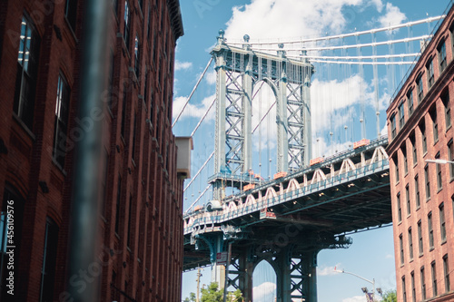 Brooklyn bridge framed by buildings in Dumbo. © Laura