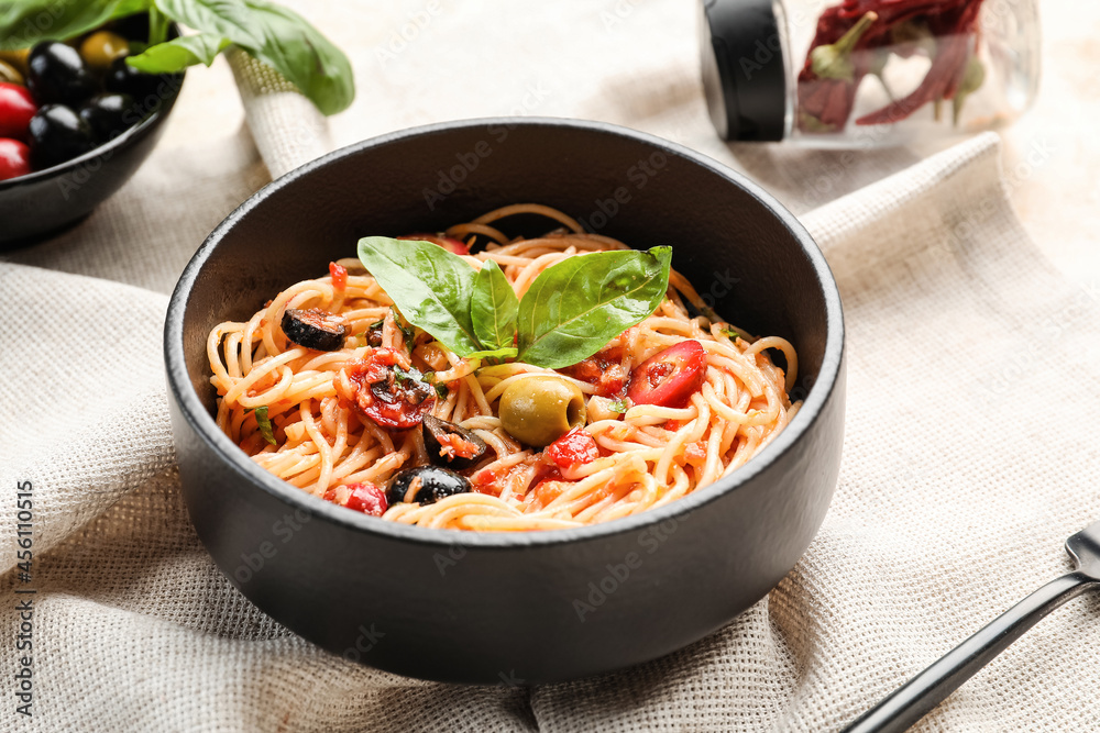 Bowl with tasty Pasta Puttanesca on table Bowl with tasty Pasta Puttanesca on table