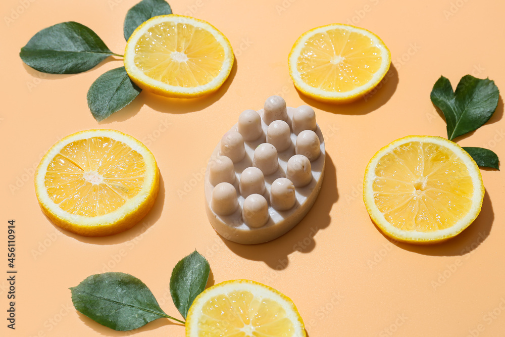 Fototapeta premium Massage soap bar and slices of lemon on color background, closeup