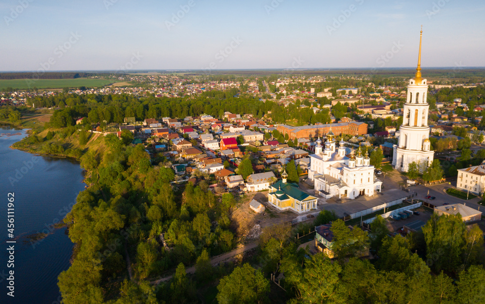 Scenic view from drone of Shuya Orthodox Resurrection cathedral with standalone bell tower on background with Teza River and cityscape, Russia..