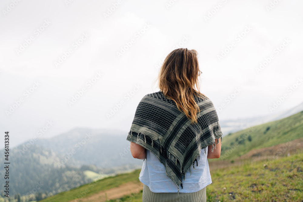 view from the back. a woman against the backdrop of a mountain landscape. 