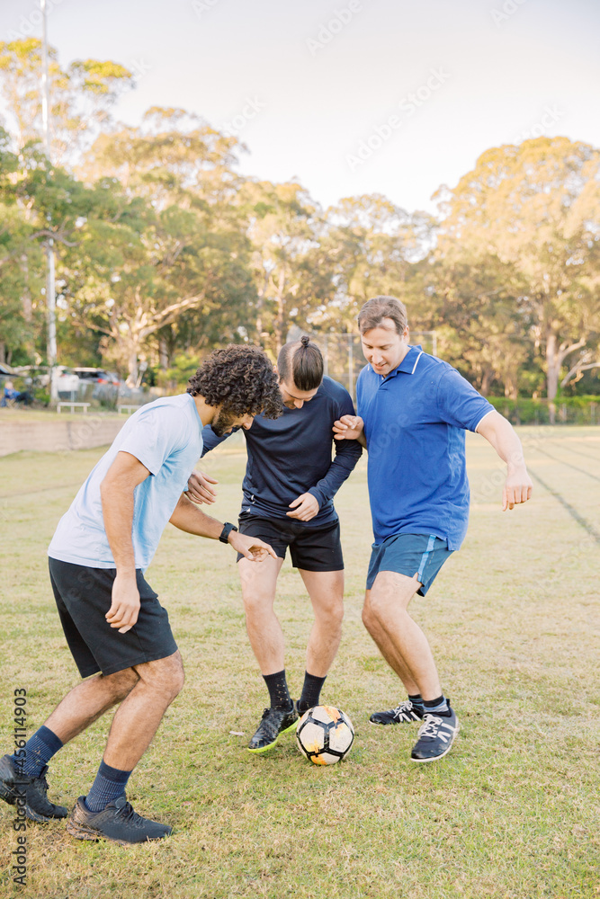 vertical shot of men playing soccer in the field on a sunny day with clear skies vertical shot of men playing soccer in the field on a sunny day with clear skies