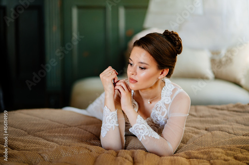 a brunette bride in a lace robe lies in bed. morning before the wedding.
