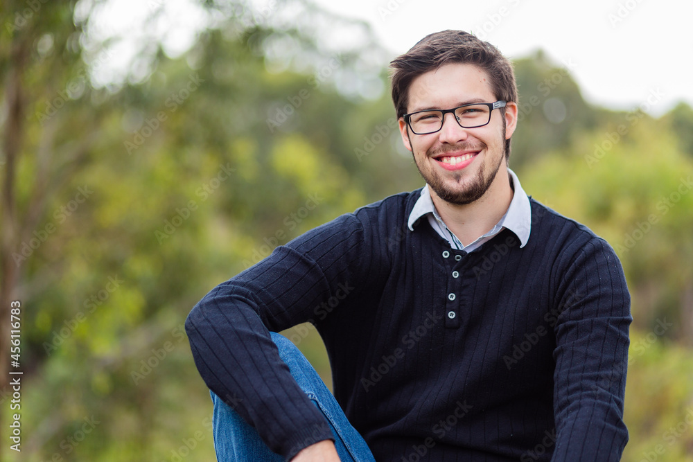 Portrait of smiling bearded man in his twenties outside Portrait of smiling bearded man in his twenties outside