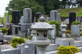 雨の日の墓地の石灯籠と墓石