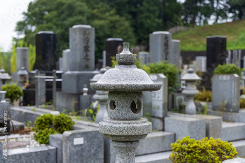 雨の日の墓地の石灯籠と墓石