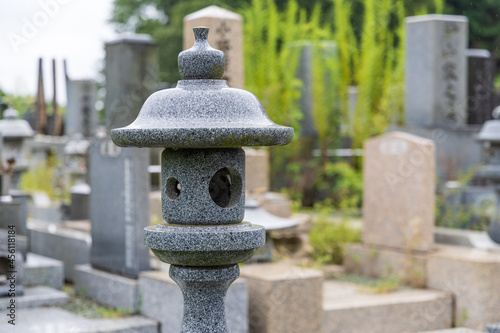 雨の日の墓地の石灯籠と墓石