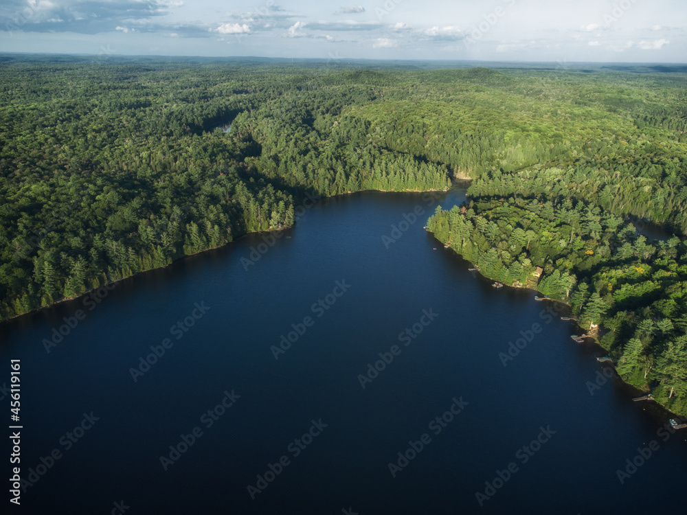 Buckskin Lake on a late summer afternoon. Aerial above the expansive crown land evergreen wilderness in Tory Hill, Highlands East, Ontario, Canada.
