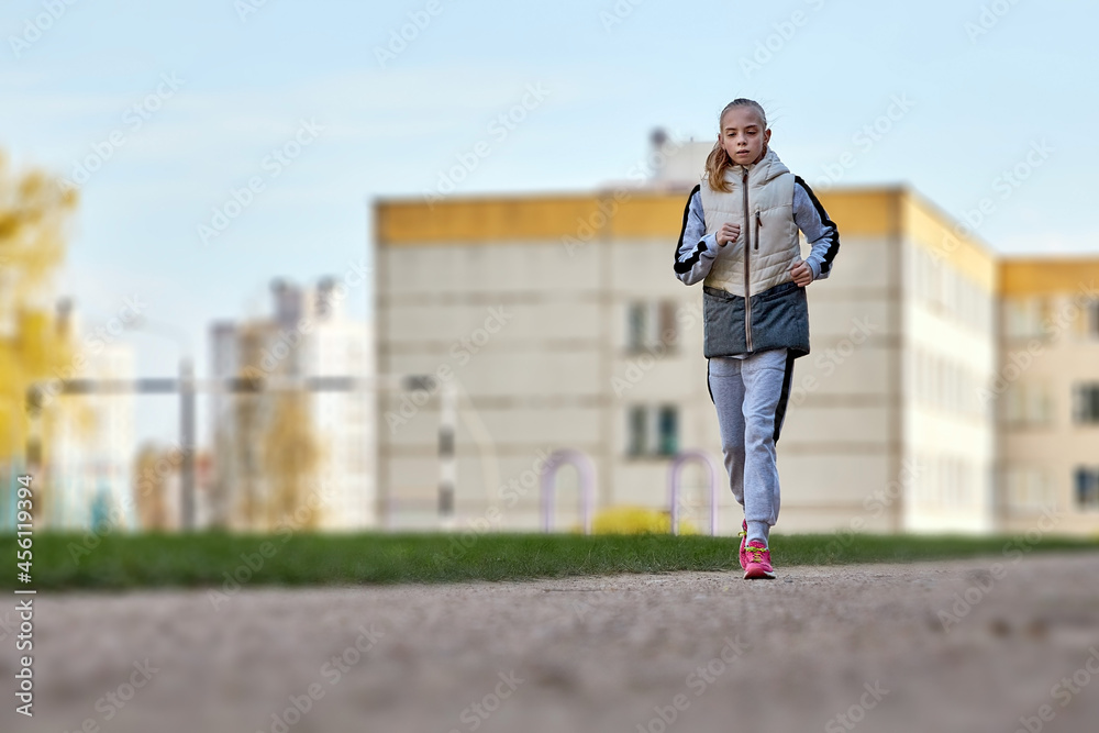 Portrait of a beautiful athletic girl running on a treadmill