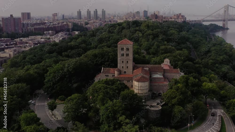 Clockwise aerial orbit pull out over The Cloisters museum in Upper Manhattan NYC with Midtown and the George Washington bridge in the distance Clockwise aerial orbit pull out over The Cloisters museum in Upper Manhattan NYC with Midtown and the George Washington bridge in the distance