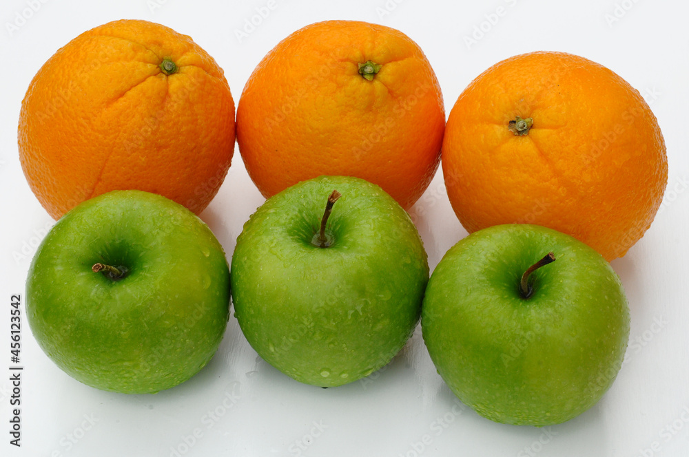 close up of green apple and orange isolated on white background close up of green apple and orange isolated on white background