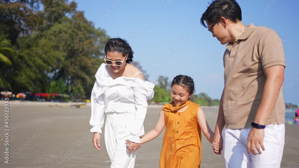 Happy family on summer holiday vacation. Asian couple with little child girl kid holding hands and walking together on tropical beach. Family enjoy and having fun outdoor activity lifestyle in summer. Happy family on summer holiday vacation. Asian couple with little child girl kid holding hands and walking together on tropical beach. Family enjoy and having fun outdoor activity lifestyle in summer.