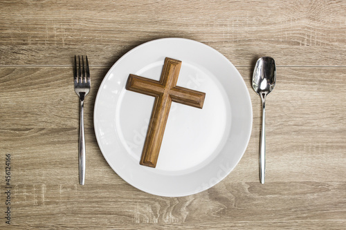 cross on a white plate on a wooden table